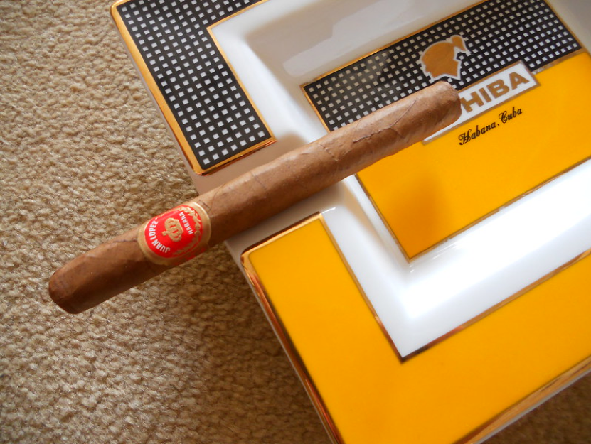 Panetela cigar resting on a cohiba ashtray